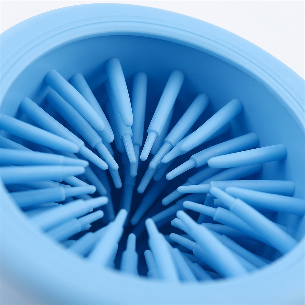 A close-up view of a light blue silicone cup or bowl interior with multiple radial silicone bristles arranged inside.