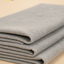 Stack of gray non-woven fabric on a beige background with text about its properties.