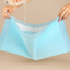 Light blue underwear with a hand holding it and another hand pouring water, on a beige background.