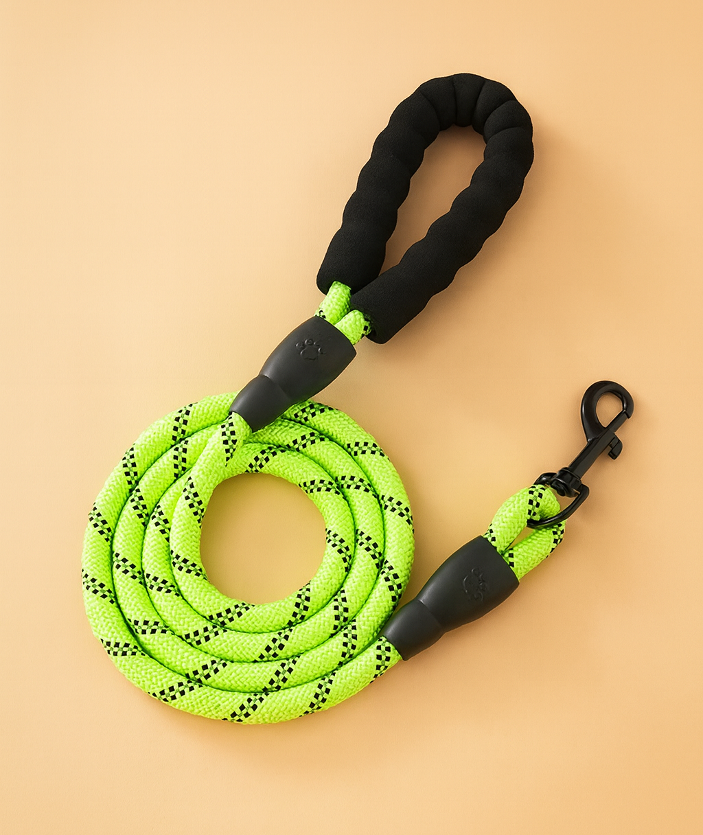 Neon green dog leash with black handle and clip on a beige background